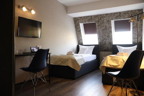 a hotel room with a bed and two chairs at Gästehaus Dresdner Hof in Zittau