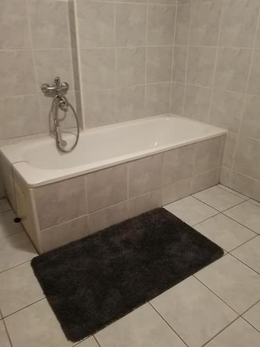 a bath tub in a bathroom with a black rug at Petrovická chalupa in Petrovice u Susice
