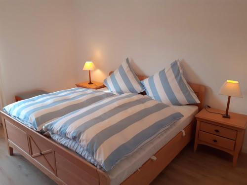 une chambre avec un lit à rayures bleues et blanches dans l'établissement Ferienwohnung Alte Post Retzen, à Bad Salzuflen