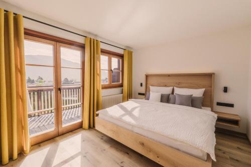 Un dormitorio con una cama grande y un balcón. en Birkhof, en Lana