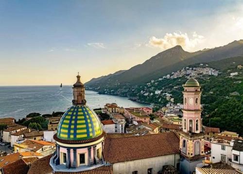 a building with a yellow and blue dome on a city at Ninfa Roda B&B in Vietri sul Mare