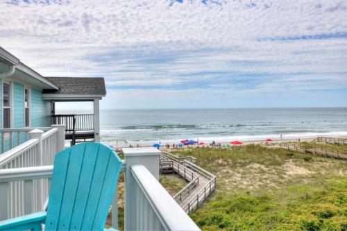 a house with a blue chair on a balcony overlooking the beach at Sands V A3 by Carolina Beach Realty in Carolina Beach