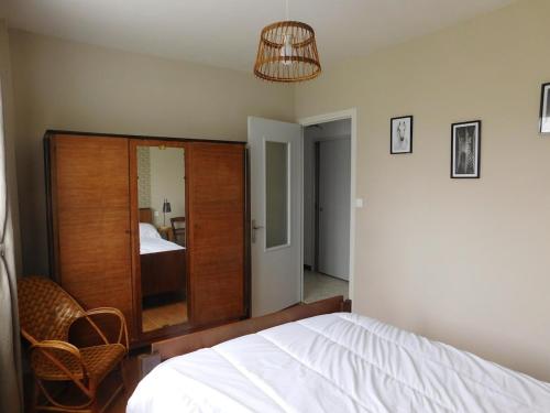 une chambre avec un lit blanc et un miroir dans l'établissement MMR 6 personnes avec cour privée et cloturée, à Saint-Saturnin