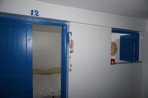 a room with a blue door and a mirror at Hostel The Endless House Anchor point in Taghazout
