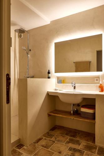 une salle de bain avec un lavabo et un miroir dans l'établissement Maison Florence, à Valliguières