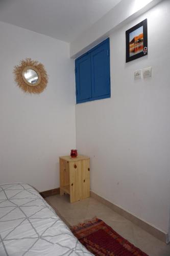 a bedroom with a blue window and a bed at Hostel The Endless House Anchor point in Taghazout