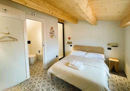 a bedroom with a white bed with a wooden ceiling at Affittacamere Casa Florens Guest House in San Benedetto del Tronto