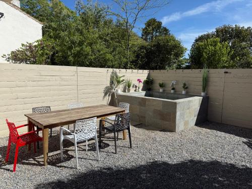 drewniany stół i krzesła z fontanną na podwórku w obiekcie Les Ecuries - 3 bedroom Gîte with plunge pool near Narbonne & the Canal du Midi w mieście Saint-Nazaire-dʼAude