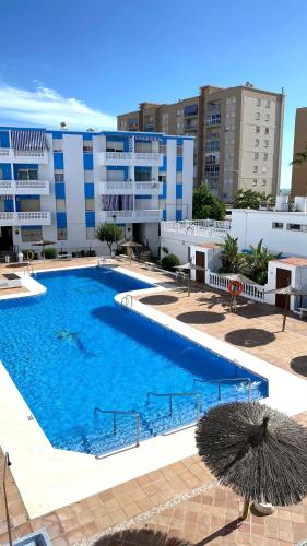 a large swimming pool in front of a building at Apartamento Las Sirenas in Chipiona