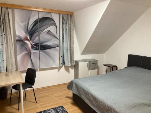 a bedroom with a bed and a table and a painting at FEWO scudici in Schkeuditz