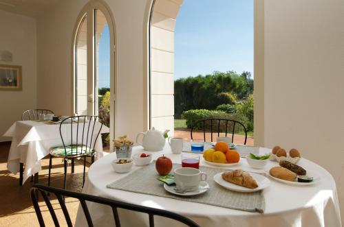 ein weißer Tisch mit Essen darüber in der Unterkunft Isola Charm B&B - Pool & Nature Stay in Syrakus