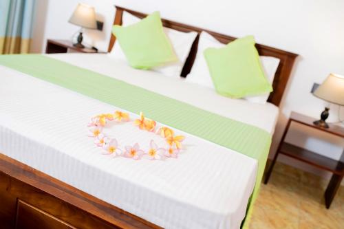 a heart shaped plate of flowers on a bed at B&B Shenal Villa Kosgoda in Kosgoda