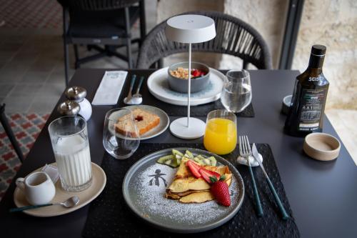 a table with a plate of breakfast food and a bottle of milk at Trulli Damari in Locorotondo