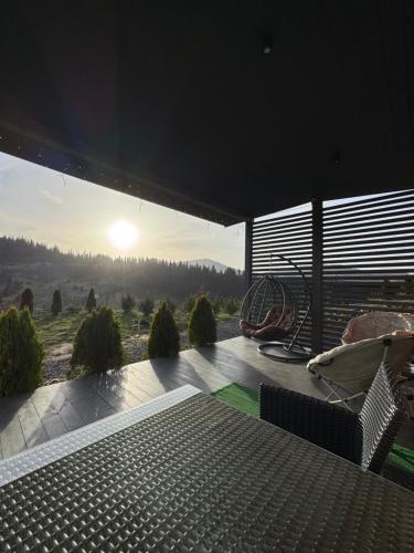 a view of the sunset from the deck of a house at Grey apartments in Slavske