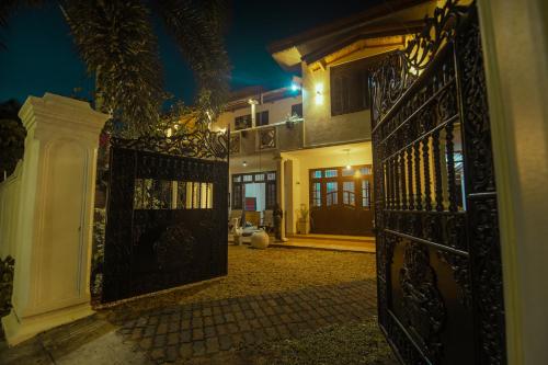 an entrance to a house with a gate at night at B&B Shenal Villa Kosgoda in Kosgoda