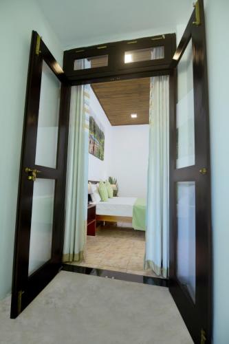 an open door to a bedroom with a bed at B&B Shenal Villa Kosgoda in Kosgoda