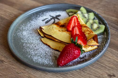 a plate of food with strawberries and kiwi slices at Trulli Damari in Locorotondo