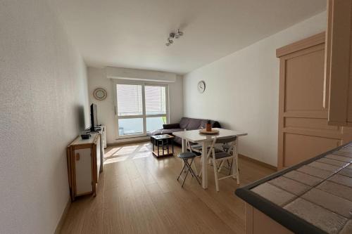 un salon avec une table et un canapé dans l'établissement Accommodation near the beach - Courseulles-sur-Mer, à Courseulles-sur-Mer