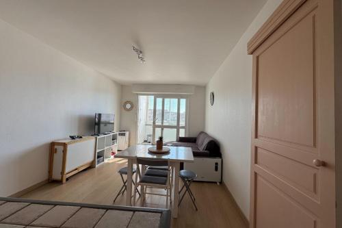 Il comprend un petit salon avec une table et une cuisine. dans l'établissement Accommodation near the beach - Courseulles-sur-Mer, à Courseulles-sur-Mer