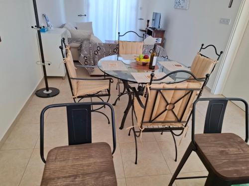 a table and chairs in a living room with a couch at Sunset Green 01 in Paphos City