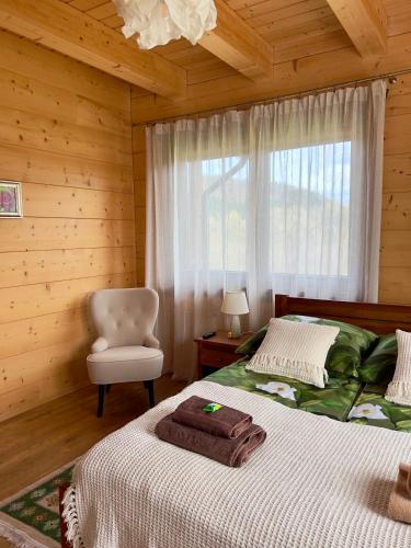 a bedroom with two beds and a chair and a window at Malinowa Chata in Cisna