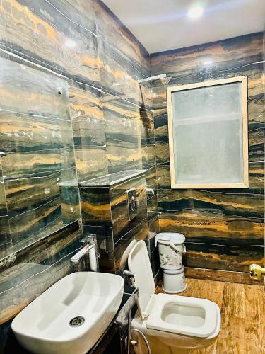 a bathroom with a toilet and a sink at Hotel Red Stone Inn Walkable from New Delhi Railway Station in New Delhi