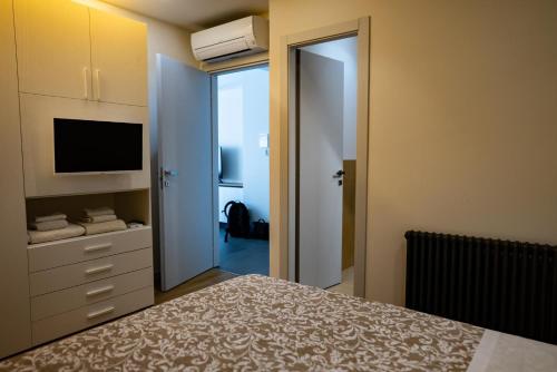 a bedroom with a bed and a tv and a closet at T&L-House in Reggio Calabria