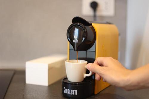 a person is pouring coffee into a coffee cup at T&L-House in Reggio Calabria