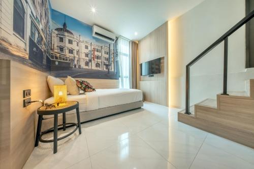a bedroom with a bed and a table and a window at U TOR Yaowarat in Bangkok