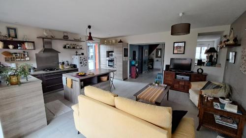 une cuisine et un salon avec un canapé et une table dans l'établissement Le Logis Mélisandre, à Candé