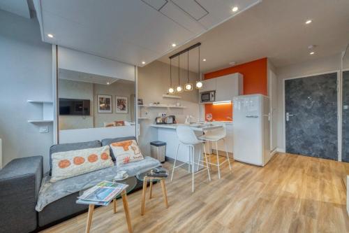 un salon avec un canapé et une cuisine dans l'établissement Le petit spacieux climatisation netflix, à Grenoble