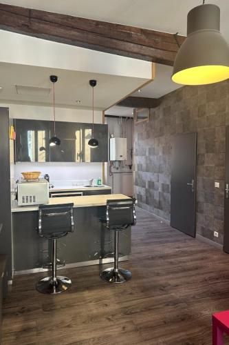 une cuisine avec deux tabourets de bar et un comptoir dans l'établissement Le Clerc, à Grenoble