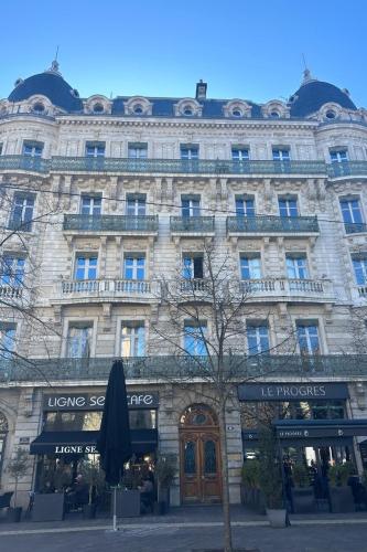 un grand bâtiment en pierre avec un arbre devant dans l'établissement Le Clerc, à Grenoble