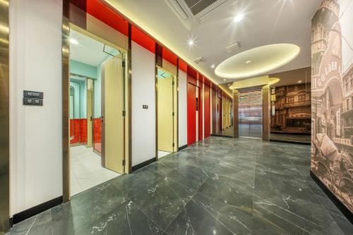 a hallway with red and white walls and a tile floor at U TOR Yaowarat in Bangkok