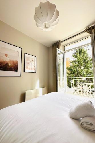 une chambre avec un lit blanc et une fenêtre dans l'établissement LAllure chic, à Grenoble