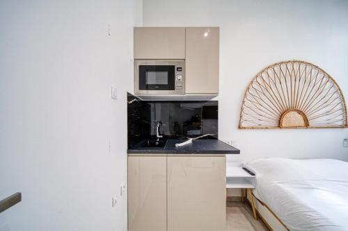 - une cuisine équipée d'un four micro-ondes et un lit dans une chambre dans l'établissement La petite estacade 4, à Grenoble