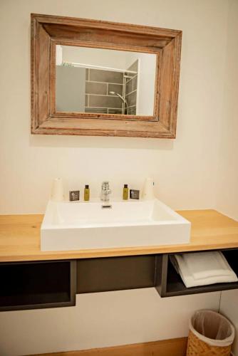 a bathroom with a white sink and a mirror at Hôtel Henri IV - Restaurant in Eauze