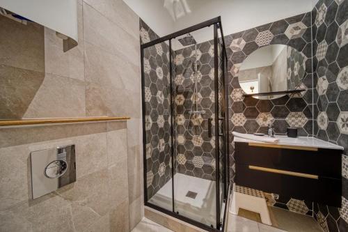 une salle de bain avec une douche, un lavabo et un miroir dans l'établissement La petite estacade 3, à Grenoble