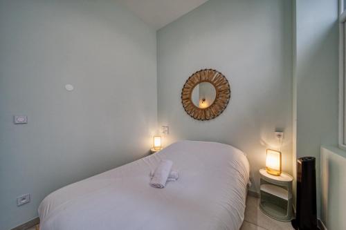 - une chambre dotée d'un lit blanc avec deux lumières et un miroir dans l'établissement La petite estacade 3, à Grenoble