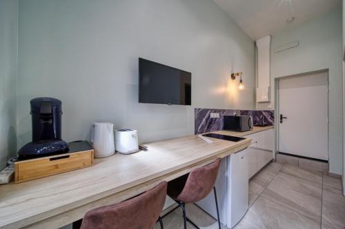 - une cuisine avec un comptoir en bois et 2 chaises dans l'établissement La petite estacade 3, à Grenoble