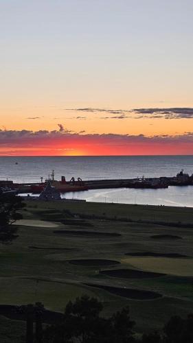 a sunset over the ocean and a golf course at Excelente Vista al Golf y al Mar in Mar del Plata