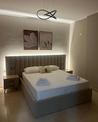 a bedroom with a bed with two towels on it at S.E.V. Sunset Homes in Vlorë