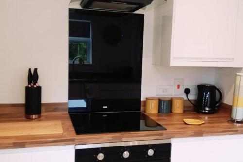 a black microwave oven sitting on top of a kitchen counter at 'Serenity in Somerset ' Self Catering House Rental Near Chard , Accomodation for Contract Workers only in Chardstock