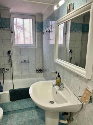 a bathroom with a sink and a mirror and a tub at Ellegant apartment in Politika in Politika
