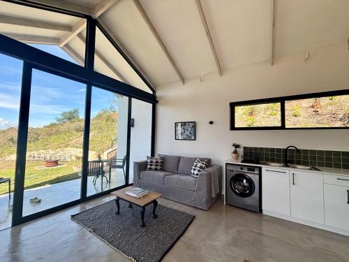 a living room with a couch and a table at Hillandale Huddle - modern forest cabin near Plett in Plettenberg Bay