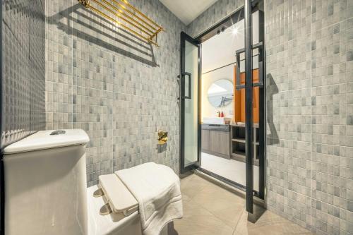a bathroom with a white toilet and a sink at U TOR Yaowarat in Bangkok