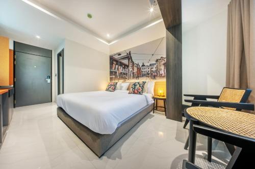 a bedroom with a bed and a table and chairs at U TOR Yaowarat in Bangkok