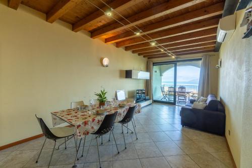 ein Esszimmer mit Tisch und Stühlen und einer Couch in der Unterkunft Home MiraGarda in Peschiera del Garda