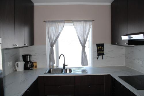 a kitchen with a sink and a window at Árbakki-Guesthouse near Egilsstaðir in Stóri-Bakki