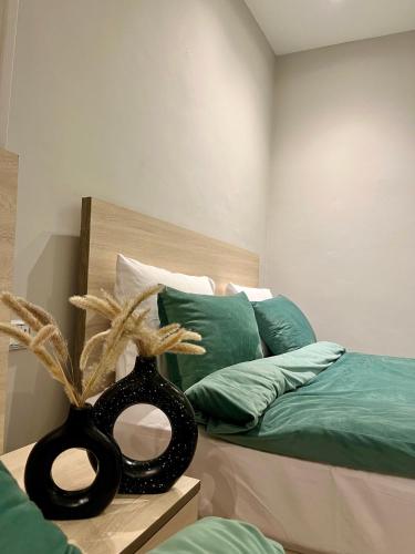 Un dormitorio con una cama con un jarrón negro sobre una mesa. en AURORA PYRAMIDS HOTELl, en El Cairo